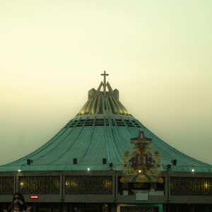 Crowd gathers at the Basilica of Our Lady of Guadalupe in Mexico City during evening hours.