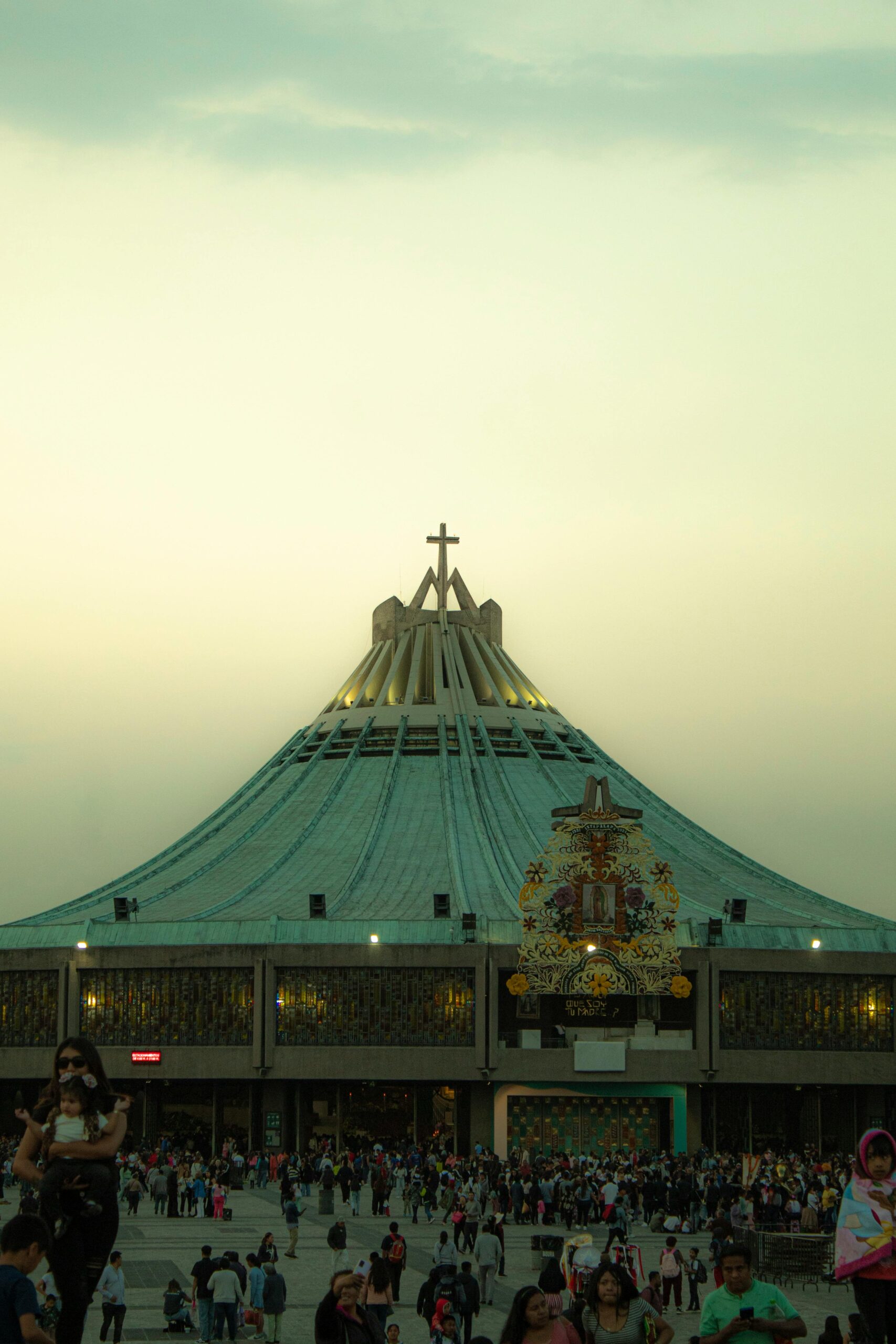 Crowd gathers at the Basilica of Our Lady of Guadalupe in Mexico City during evening hours.